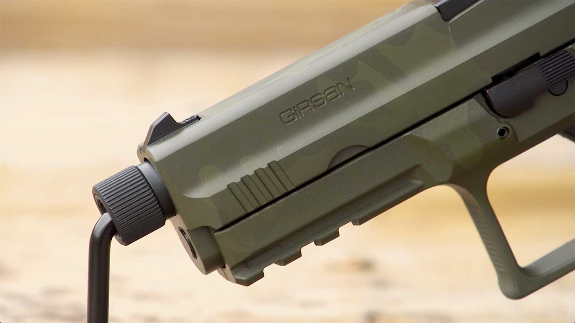 A black thread cap sits at the muzzle end of the EAA Girsan MC9 Disruptor's green slide.