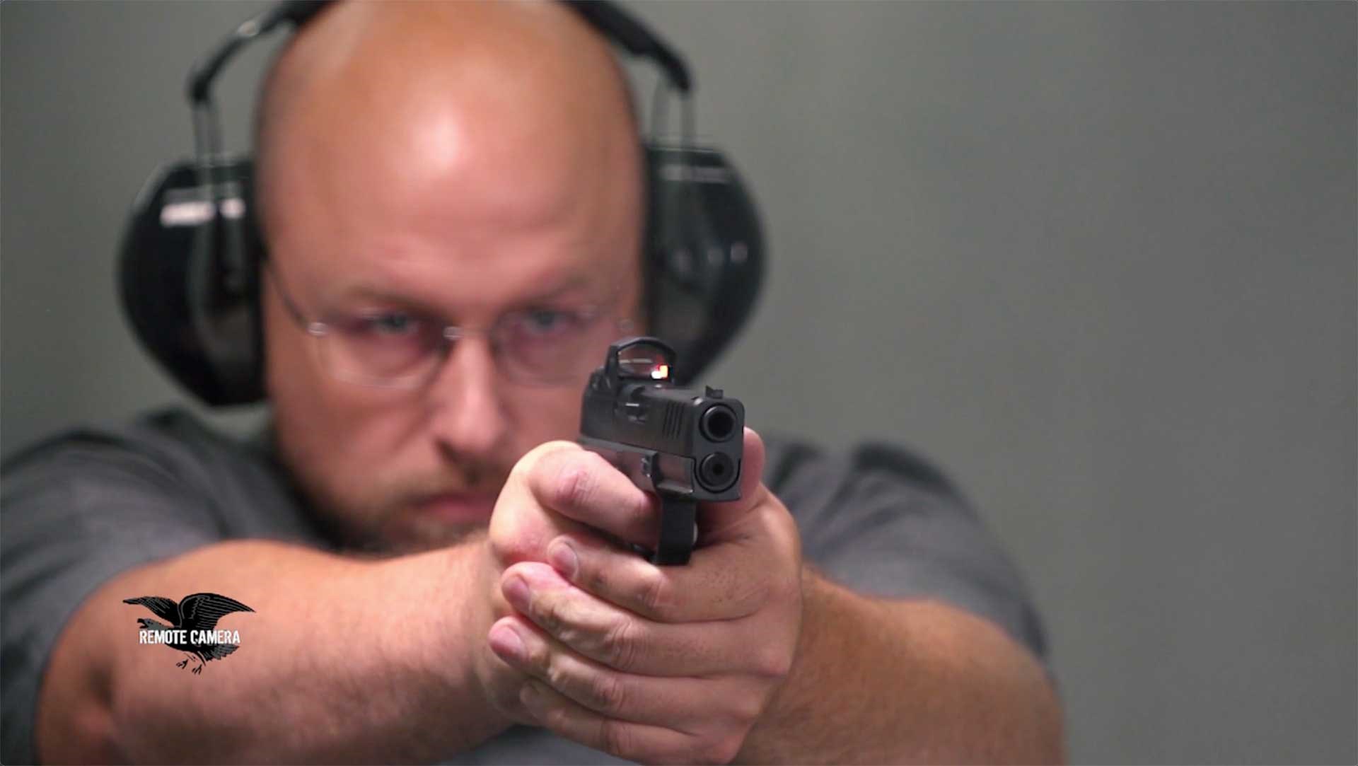 Man grabs the Springfield Armory Hellcat Pro handgun with both hands and aims