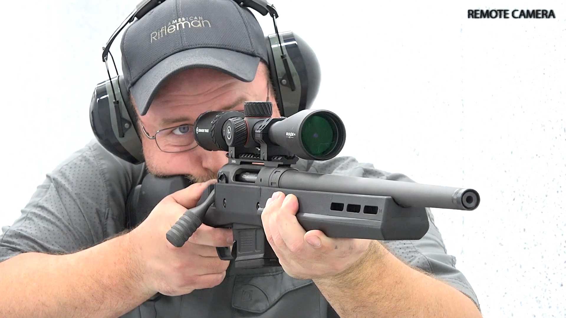 Man wearing hat and protective gear shooting bolt-action Savage 110 Magpul Hunter rifle
