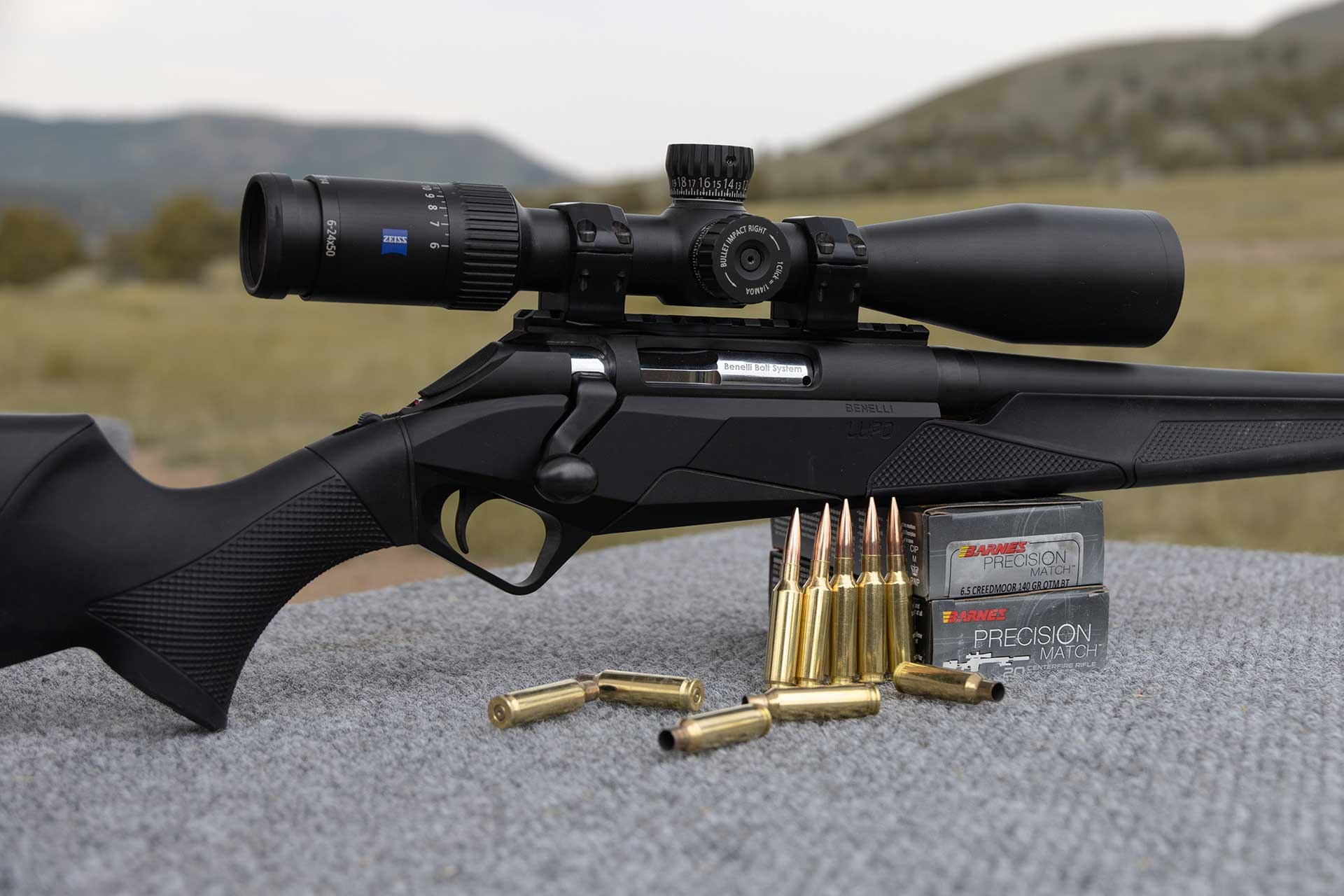 A Benelli Lupo rifle sitting on a shooting bench next to Barnes Precision ammunition.