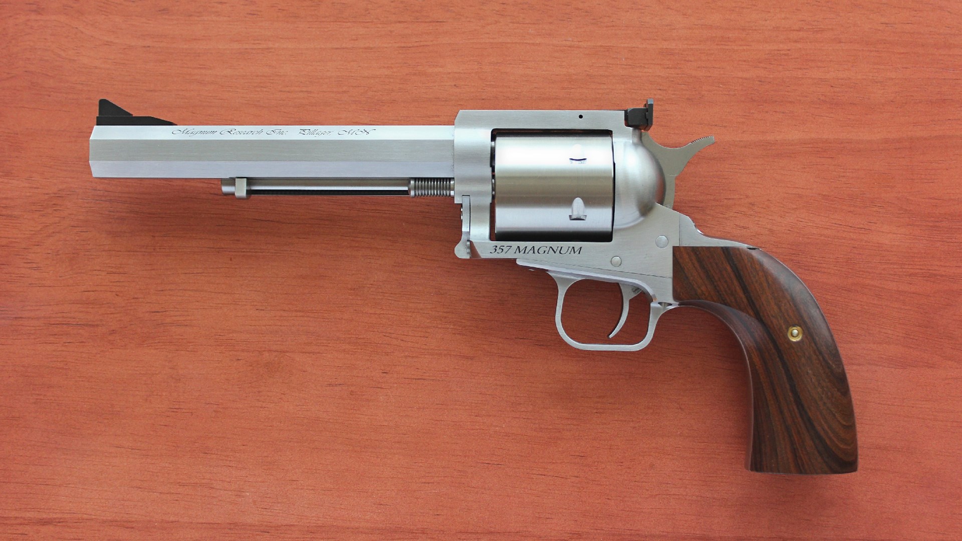 Left-side view stainless steel Magnum Research Biggest Finest Revolver on wood background