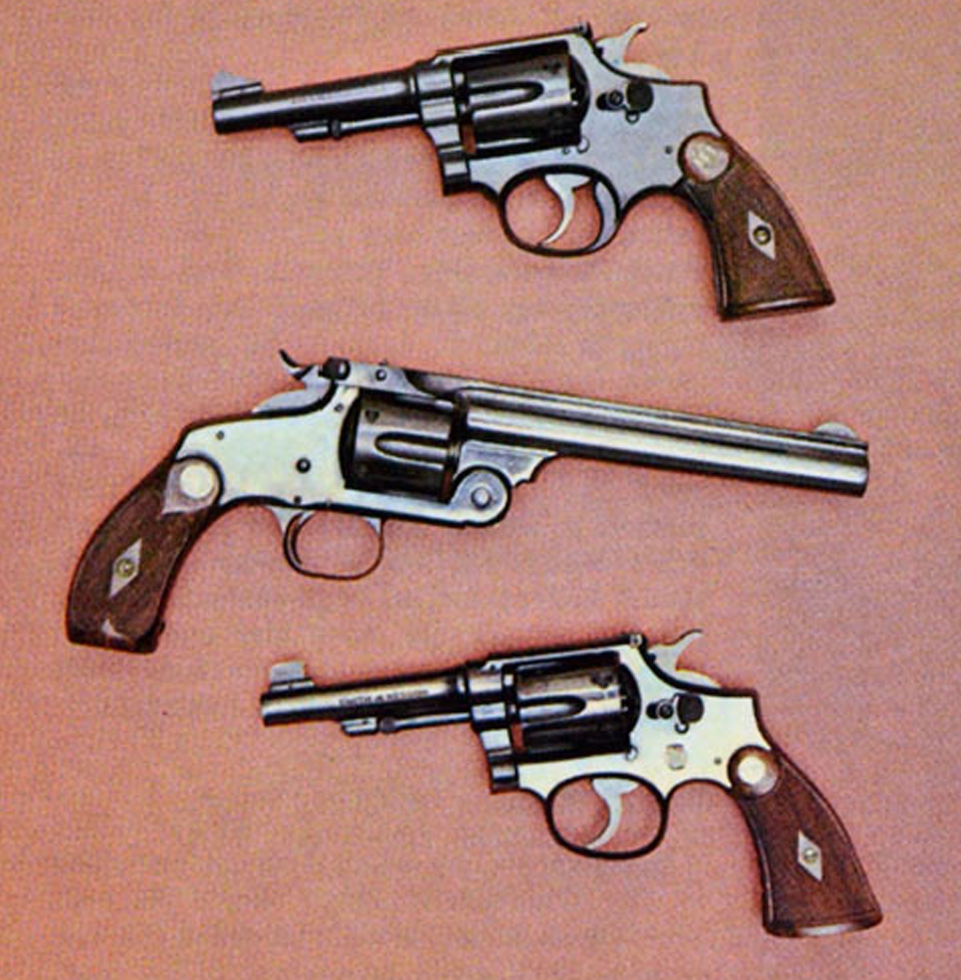 Smith & Wesson .38's include top-break Model 1891, cal. .38 S&W (center) and pair of .38 S&W Special Military and Police Target models (discontinued 1941). Top revolver has special trigger guard for double-action firing.