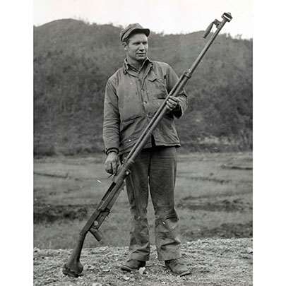 A Marine examines a semi-automatic PTRS-41 anti-tank rifle chambered in  14.5x114 mm.