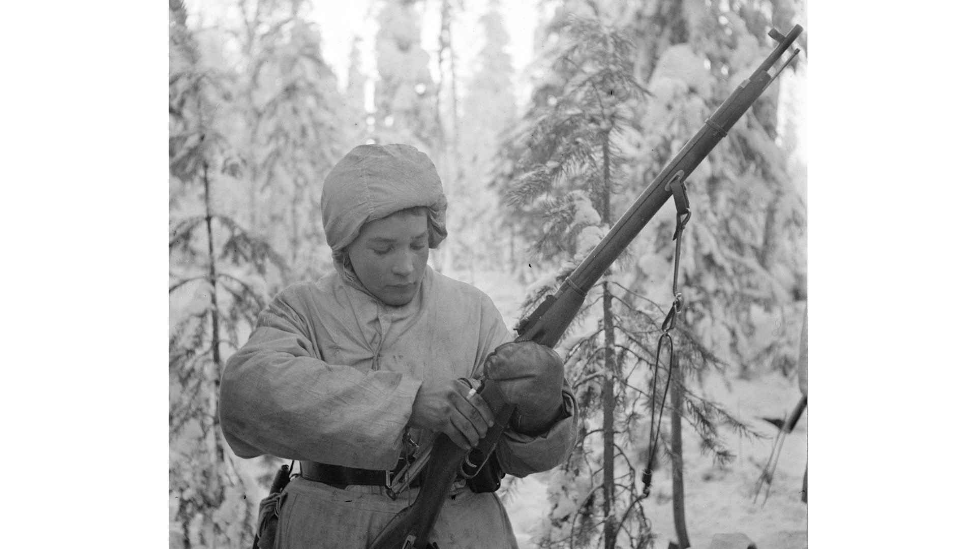 Person in snow with white clothes laoding bolt-action mosin-nagant rifle