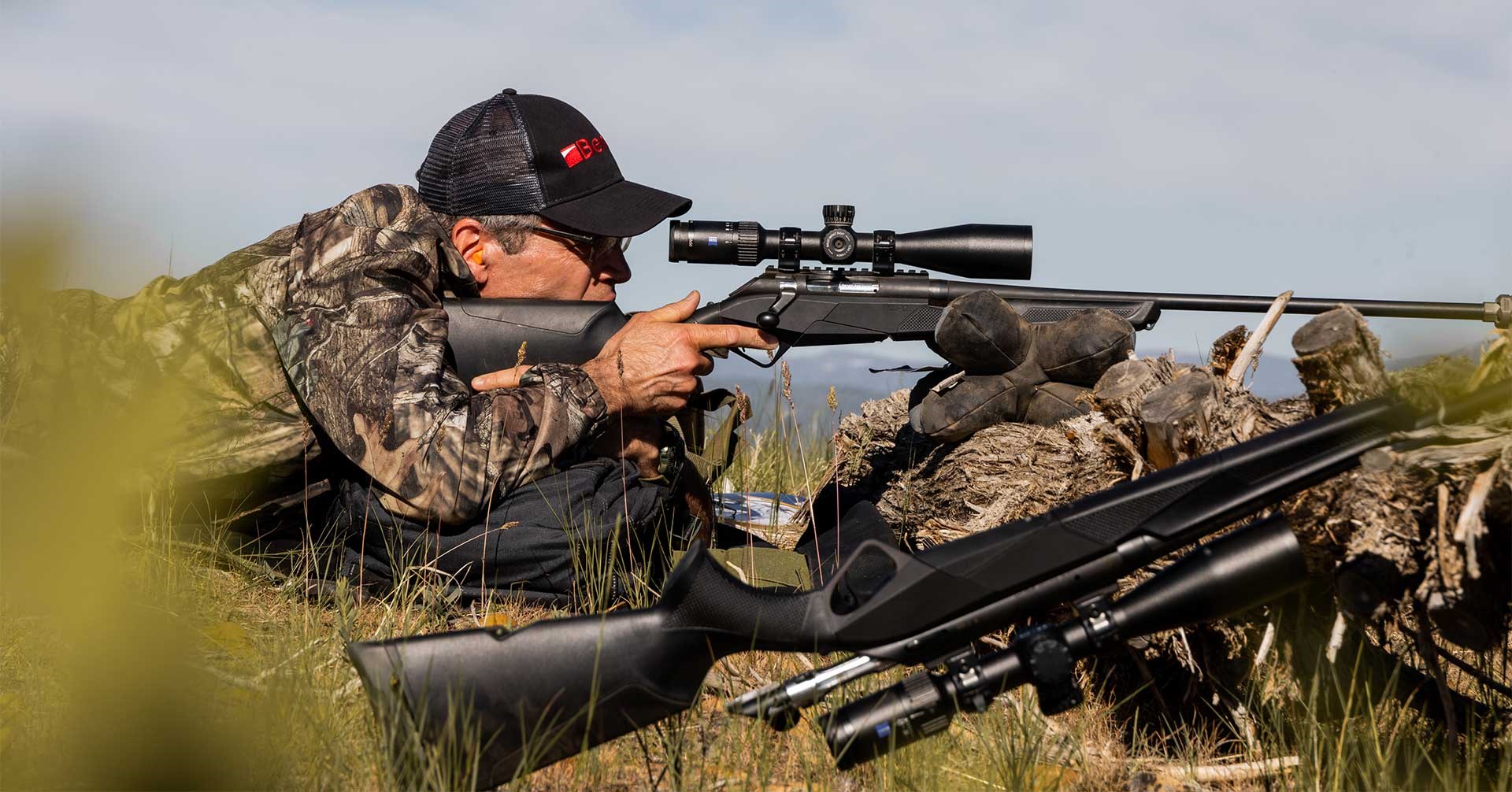 A shooter mounts his Benelli Lupo rifle in the field while shooting off a bag rest.