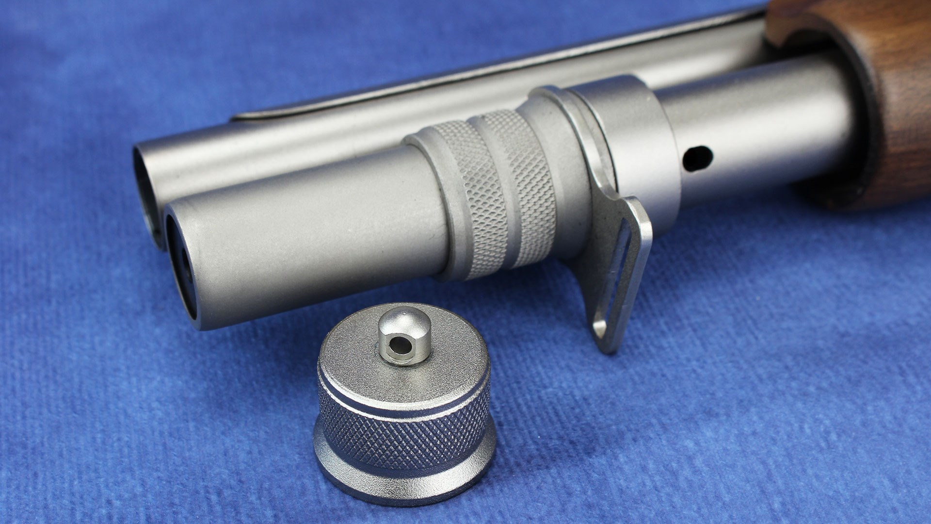 An installed tube extension cap compared with the standard magazine tube cap.