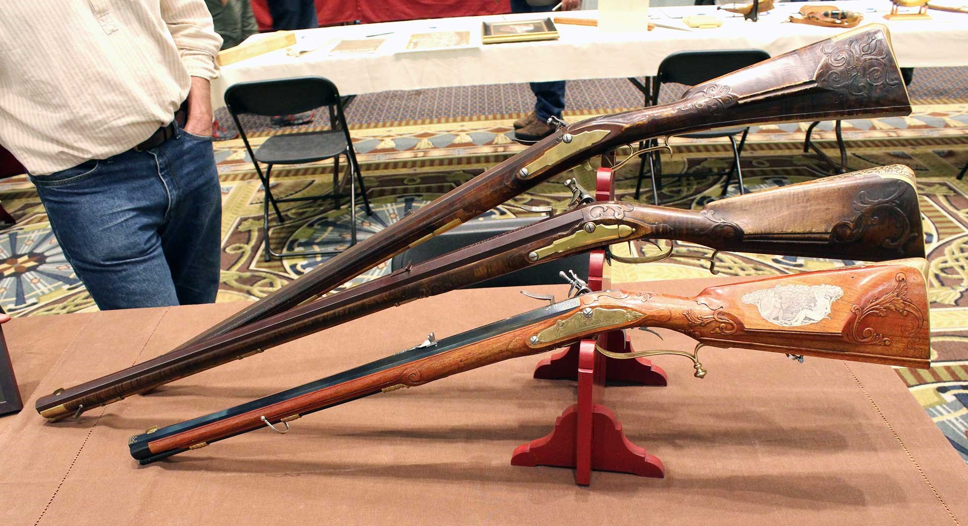 Three short flintlock Jaeger rifles shown on a table at the CLA Show.