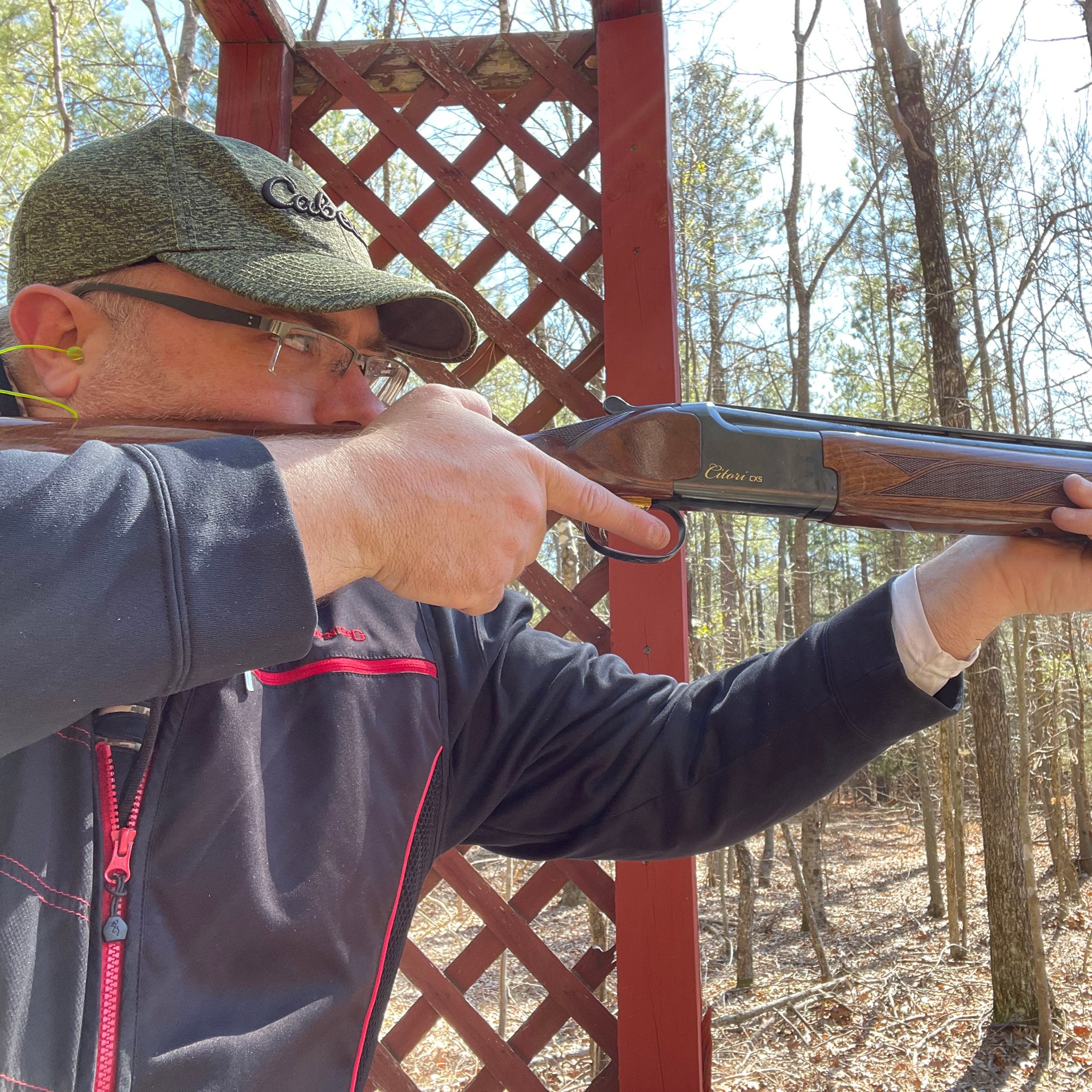 Man outdoors holding point shotgun nra safety rules finger off trigger until ready to fire