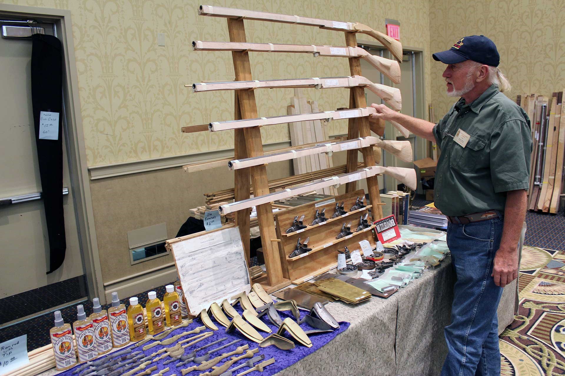 Unfinished flintlock rifle kits displayed at the CLA show are inspected by a show attendee.