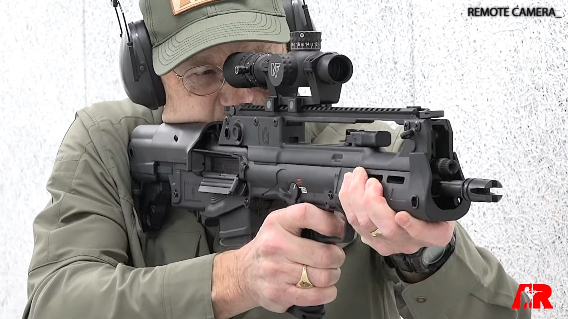 Editor In Chief American Rifleman's Brian Sheetz on the range with Springfield Armory Hellion Bullpup Rifle carbine black gun indoors white background safety gear remote camera
