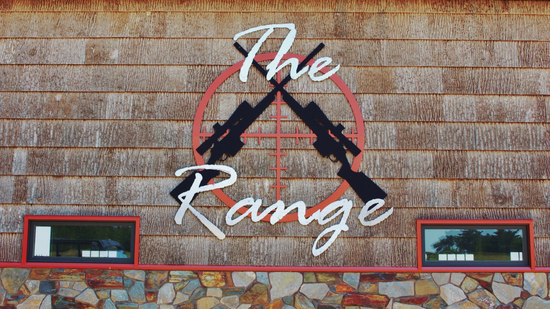 Brick wall stone with logo rifles cross text on wall noting "THE RANGE"