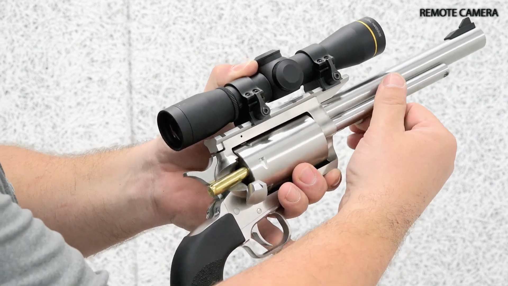 Magnum Research BFR revolver in hands arms gun stainless steel revolver Leupold Scope extraction ammunition