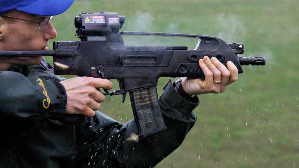 Mark Keefe shooting rifle outdoors wet rain gun testing smoke splash green grass