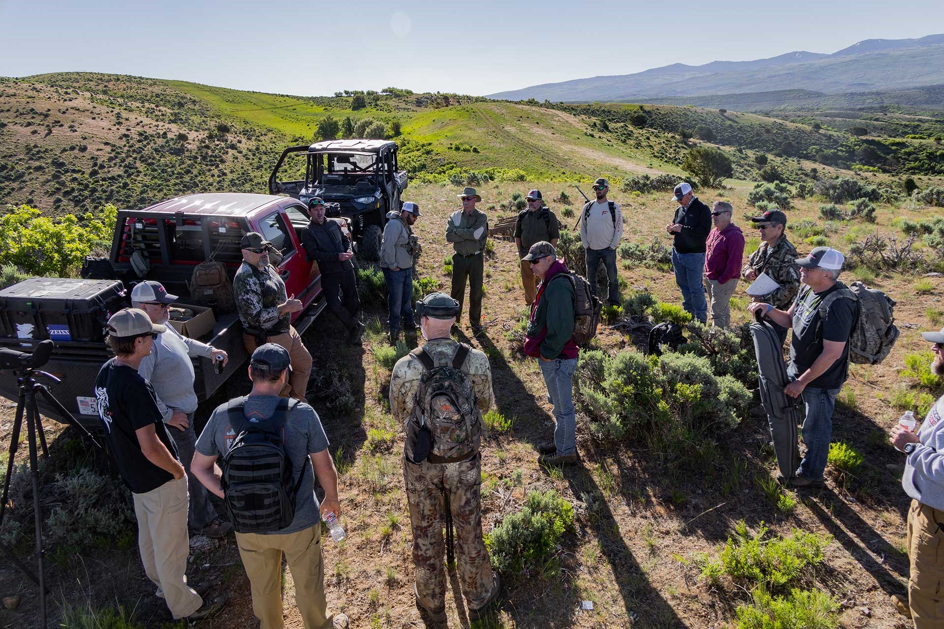 A group of students gathers around trucks in the wilderness at the Outdoor Solutions Long Range School.