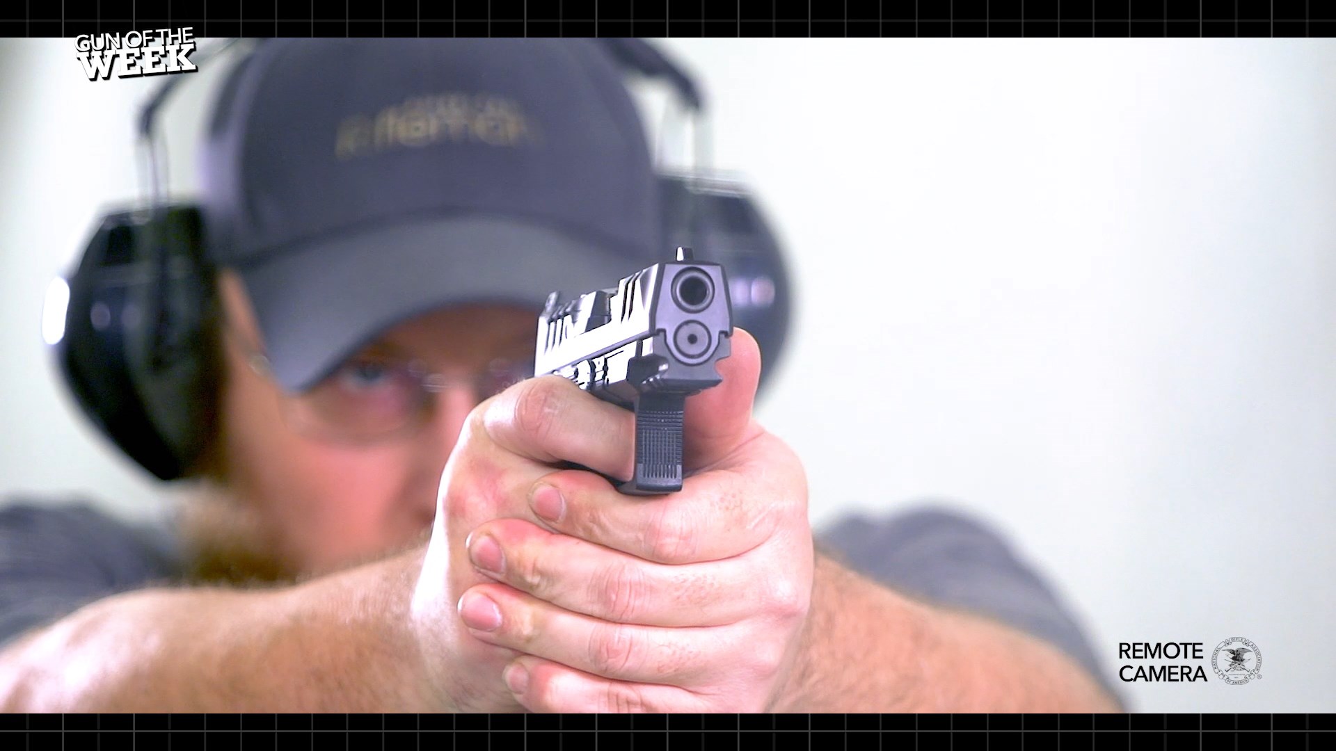 man shooting indoors white range wearing ear muffs hat shoot gun pistol walther arms pdp f-series for gun of the week video remote camera