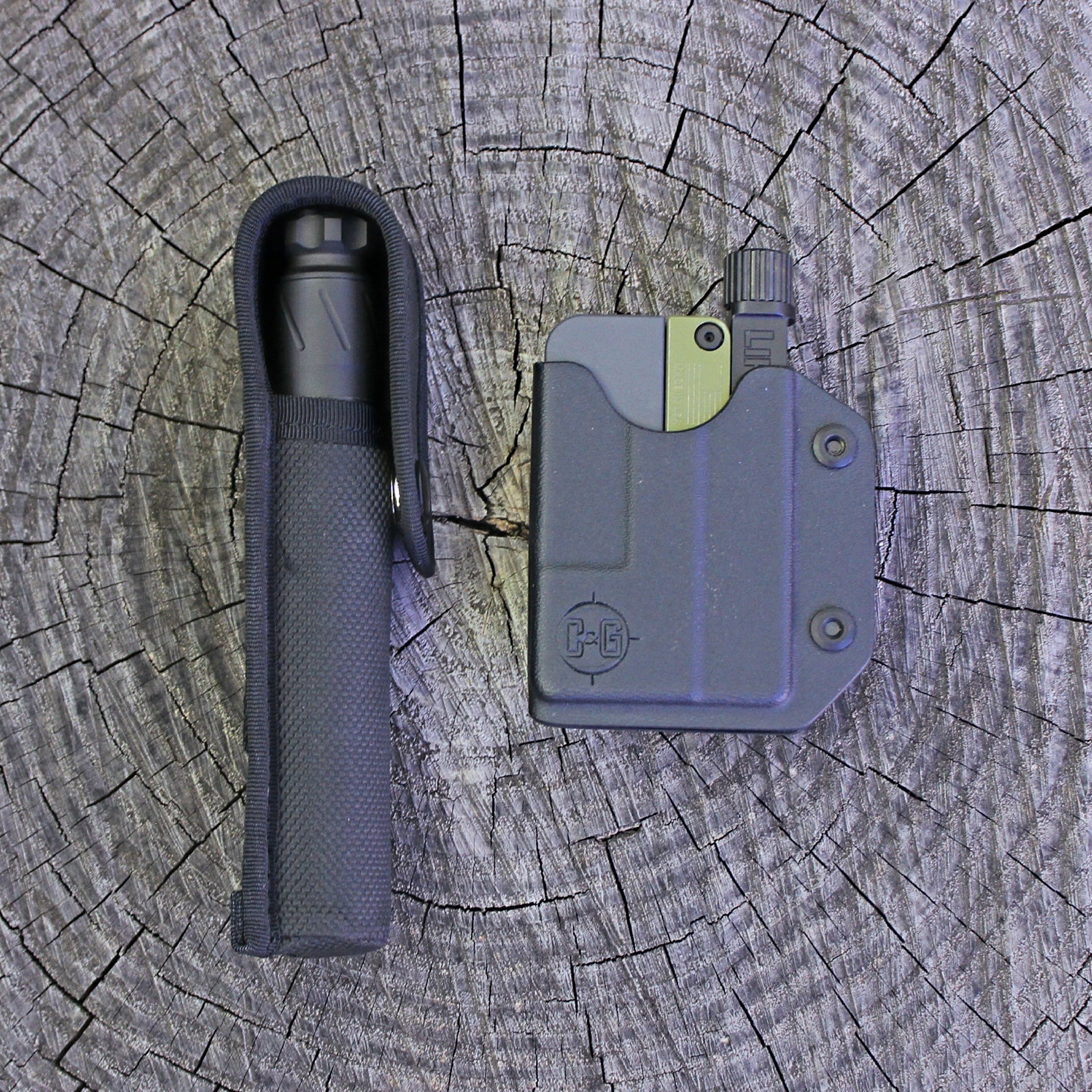 Trailblazer LifeCard single-shot pistol in kydex holster suppressor in holster shown on wood log
