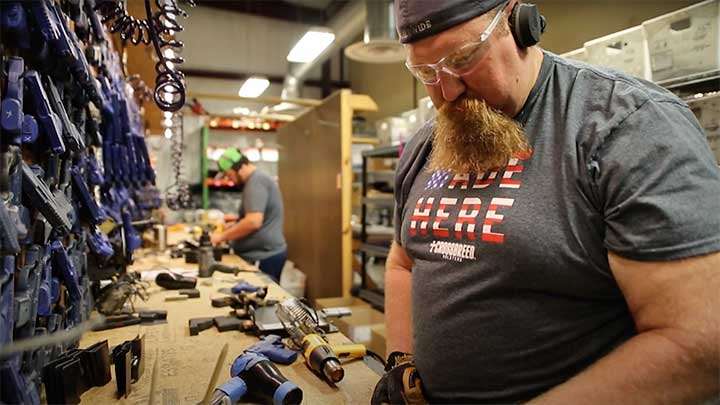 The craftsmen of Crossbreed making the holsters.