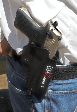 gun in holster on hip outdoors