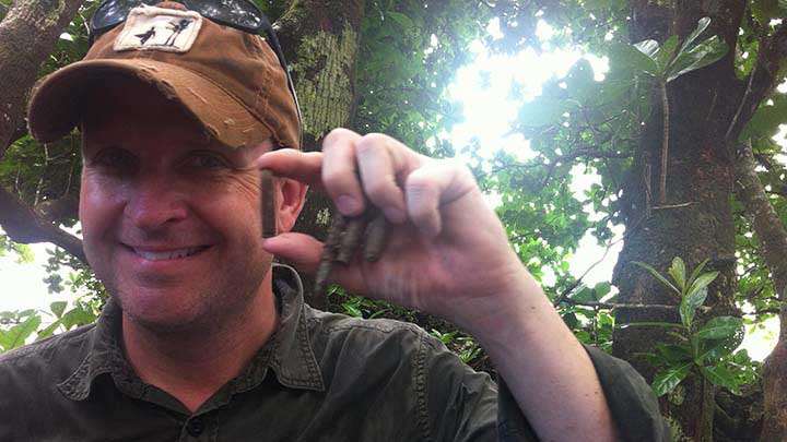 The author holds up live cartridges and spent shell casings he found at “The Point” during a visit to Peleliu in March, 2014.