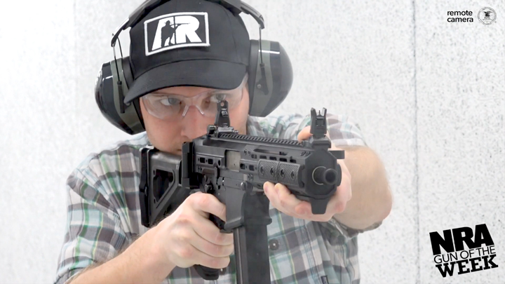 Man with protective shooting gear on a range facing the camera with a LWRCI SMG 45.
