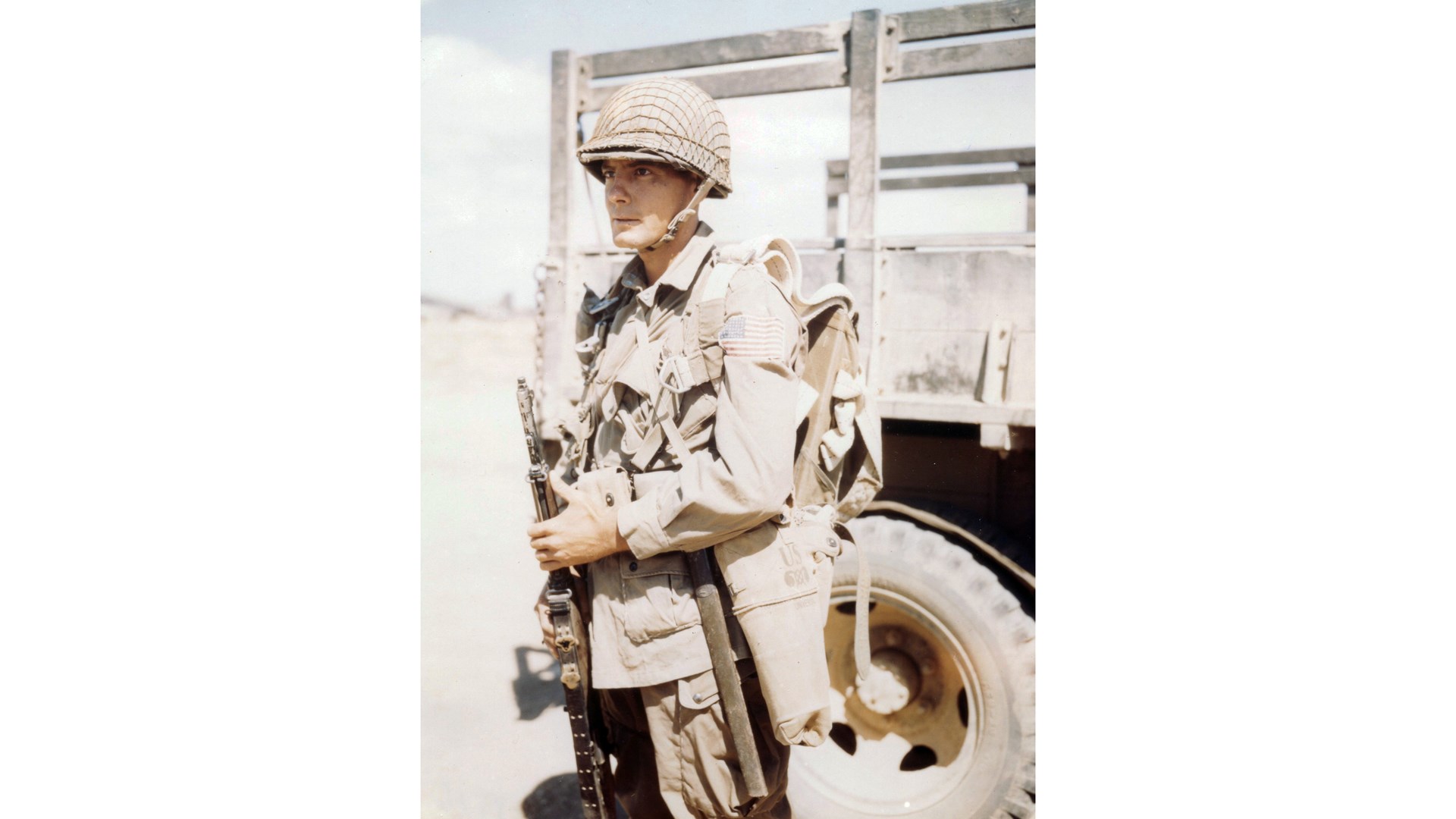 All-American Paratrooper: A member of the 82nd Airborne Division in the North African dust, ready for the paratroop assault on Sicily. He carries the M1 Garand rifle. NARA
