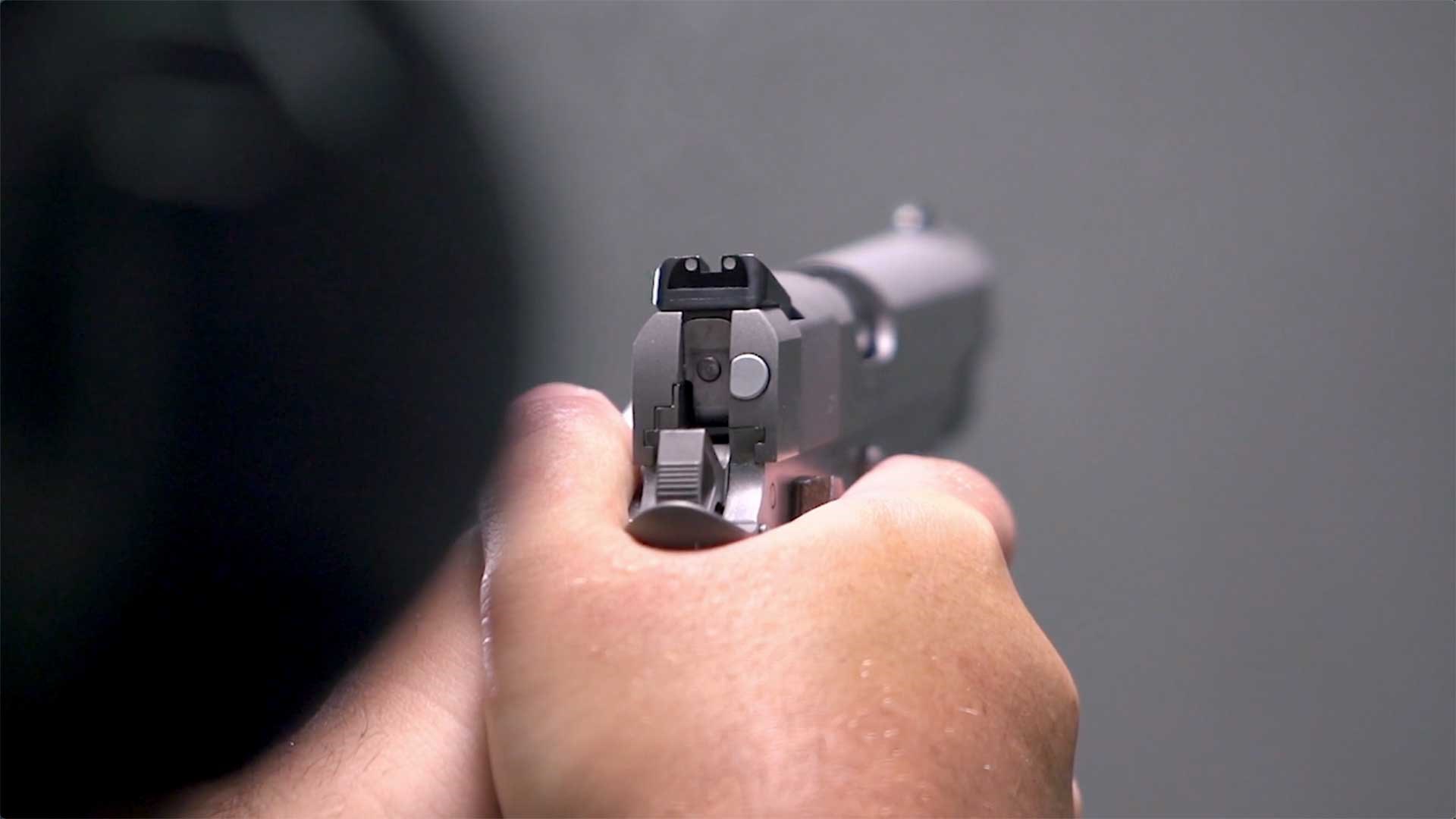 A man aiming the Springfield Armory Garrison 1911 downrange.