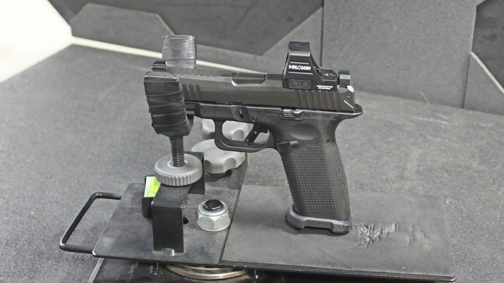 Left-side view of Lone Wolf Timberwolf 19X 9 mm pistol in cradle on range indoors shown with holosun red-dot optic