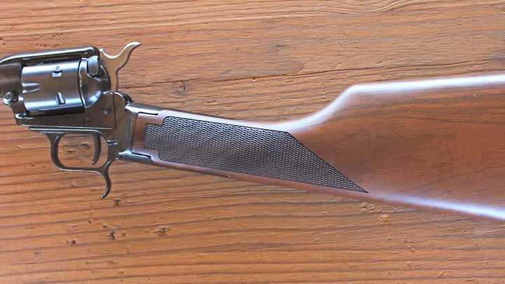 The wood stock is a straight "S-stock" profile with checkering at the grip.