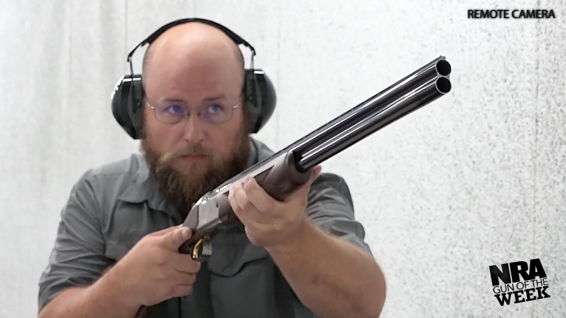 Man with over-under Browning shotgun indoors shooting gun 16 gauge remote camera front angle