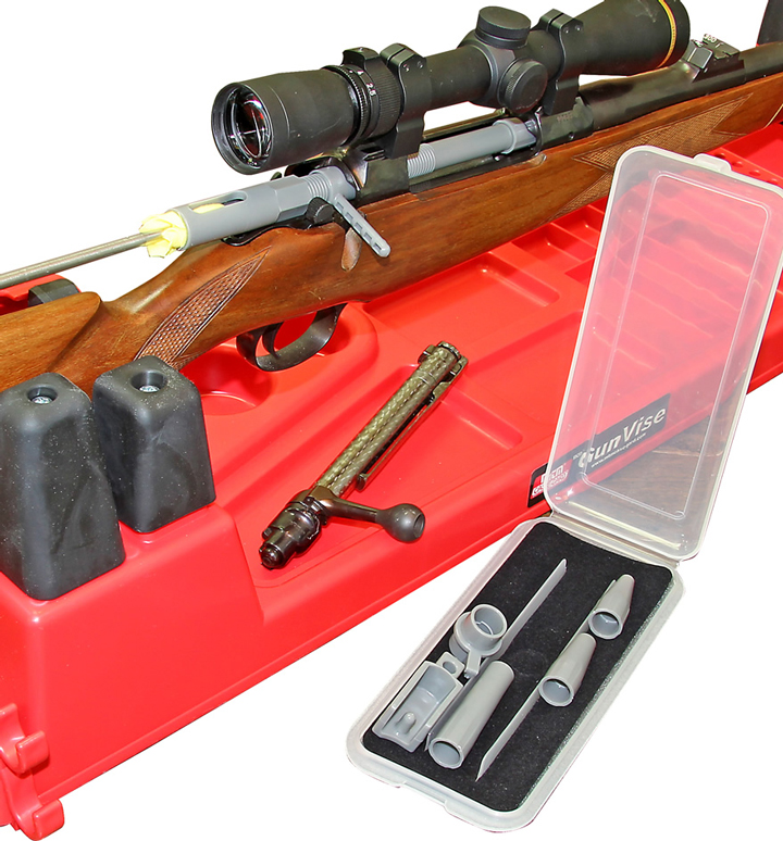 Rifle on red cleaning station with a clear box with accessories.