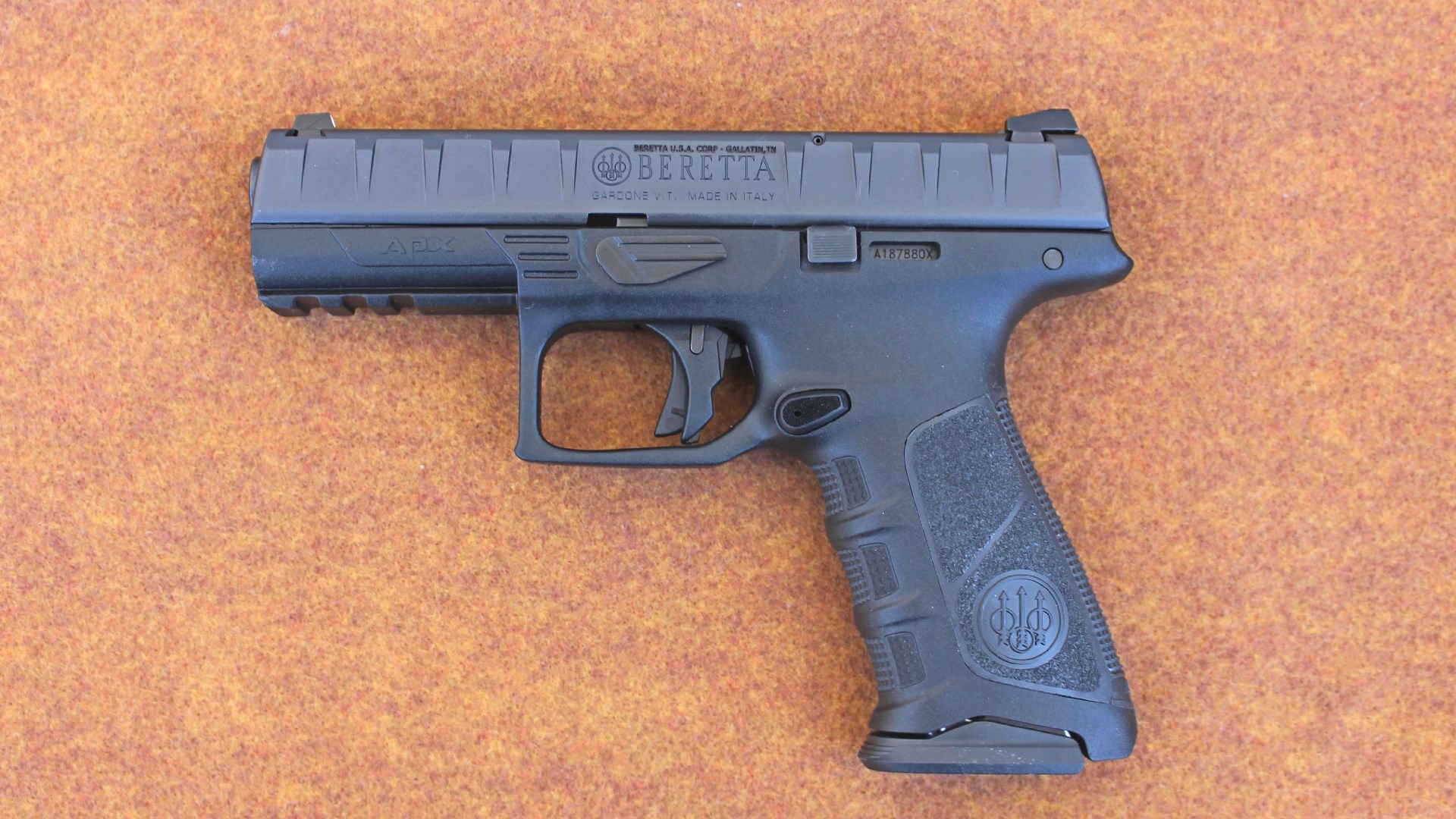 Beretta APX pistol black color left-side view on brown background