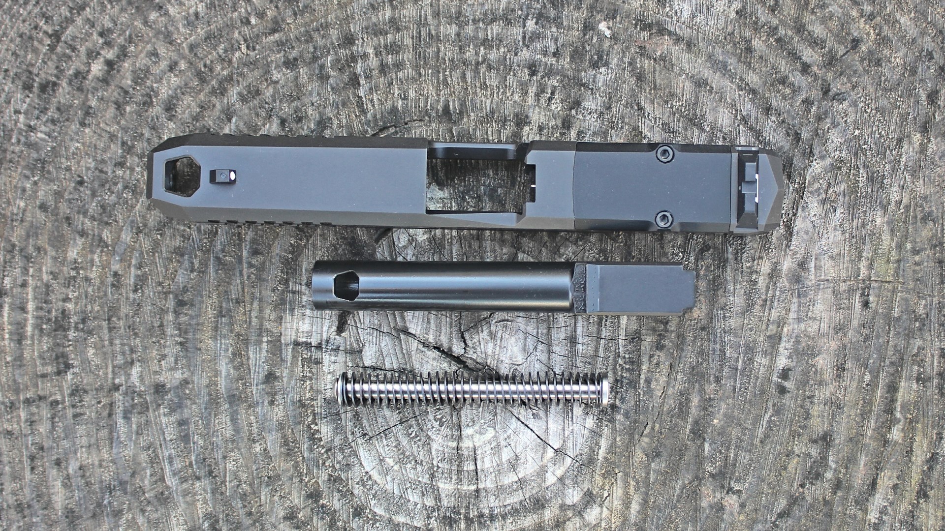 LR01C slide assembly with barrel and recoil spring on log