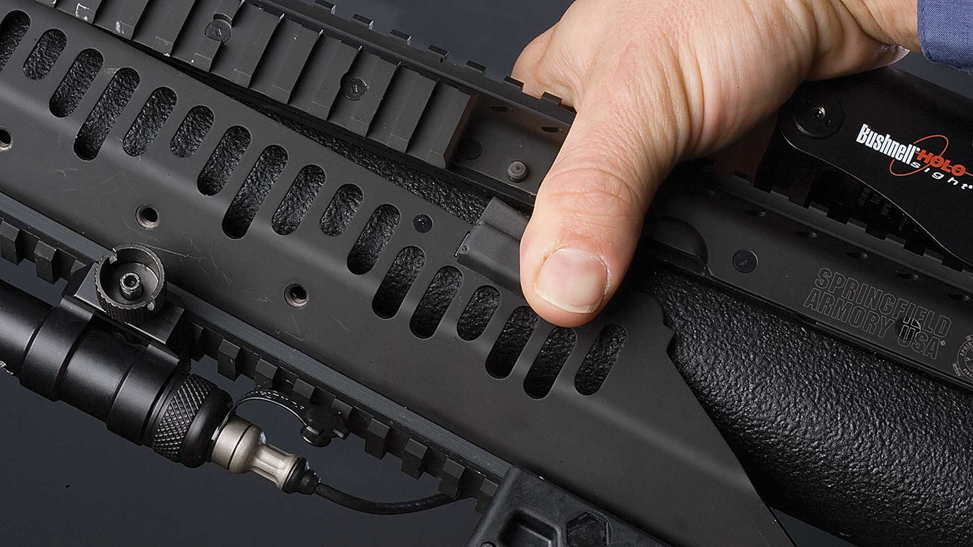 Removing the bottom portion of the SOCOM II’s Cluster Rail System is as easy as depressing two buttons and swinging the unit away from the rifle.