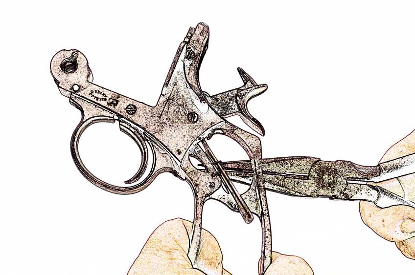 revolver parts cartoonized in hands with pliers