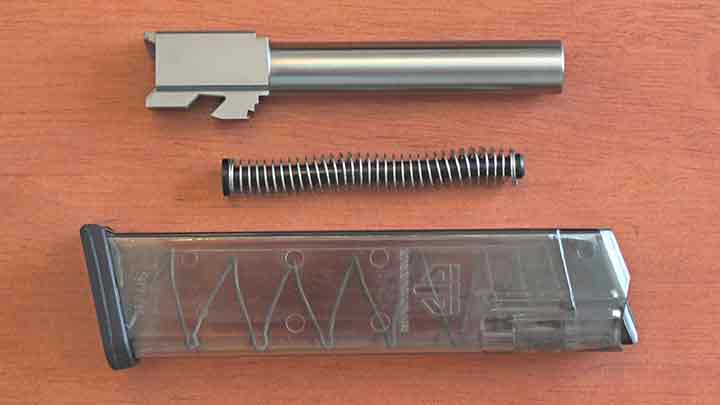 The replacement parts from AIM Surplus including its G22 9 mm conversion barrel, stock G22 main spring, and ETS G17 compatible 9 mm magazine.
