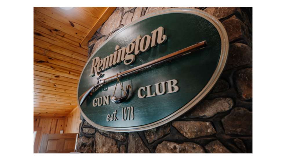 Remington Gun Club est. 1978 sight flintlock rifle sign chimney stone cabin indoors