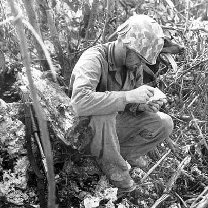 A Marine War Dog handler reads a note just delivered by his canine messenger during the battle. Note the Model 1897 Trench Shotgun at left. Marine Corps Archives &amp; Special Collections OFFICIAL USMC PHOTOGRAPH.