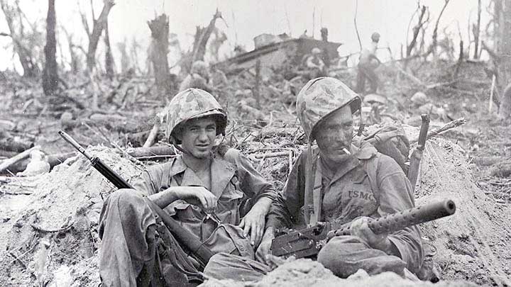 1st Marine Division PFCs Gerald P. Thursby of Akron, Ohio, and Douglas D. Lightheart of Jackson, Mich., smoking cigarettes shortly after having landed on Peleliu’s “White Beach 2”. (National Archives 127-N-97628).
