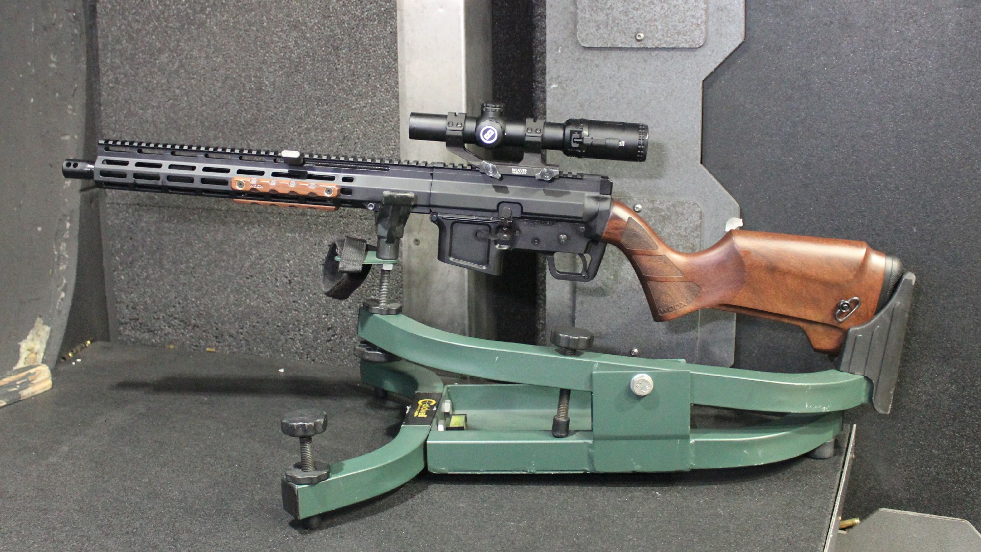 FM Products Rancher Rifle left-side view in cradle rest at shooting range indoors shown with Bushnell riflescope