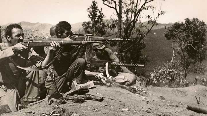 Approximately 80 miles north of Lashio, Burma, U.S. Army infantrymen engage Japanese troops in a fight for control of a section of the Old Burma Road. The overland link was a vital supply connection for Allied troops fighting in the China-Burma-India Theater. The man closest to the camera is armed with an M1903A3 rifle that has the word “HELL” etched in the wood of the stock. (National Archives and Records Administration/U.S. Army Signal Corps 111-SC-200054-5).