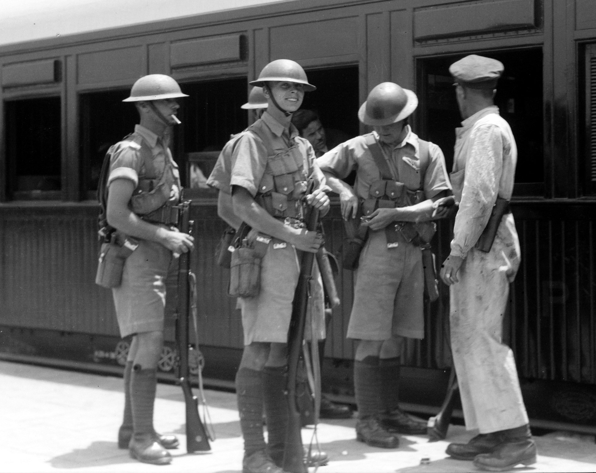 British troops guarding the railway station at Haifa during the 1936 revolt.  Equipped with tropical kit and the excellent Rifle No.1 Mk. III, the men were at least well-supplied, if not well-informed about the confusing situation.  The railway worker carries an unidentified revolver.  Library of Congress image