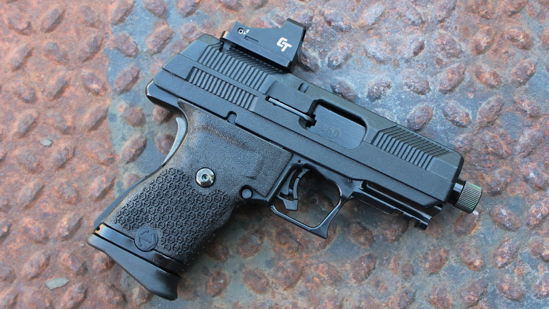 Hi-Point Firearms YC9RD right-side view gun pistol black 9mm on treadplate diamond plate rusty metal background crimson trace optic on slide