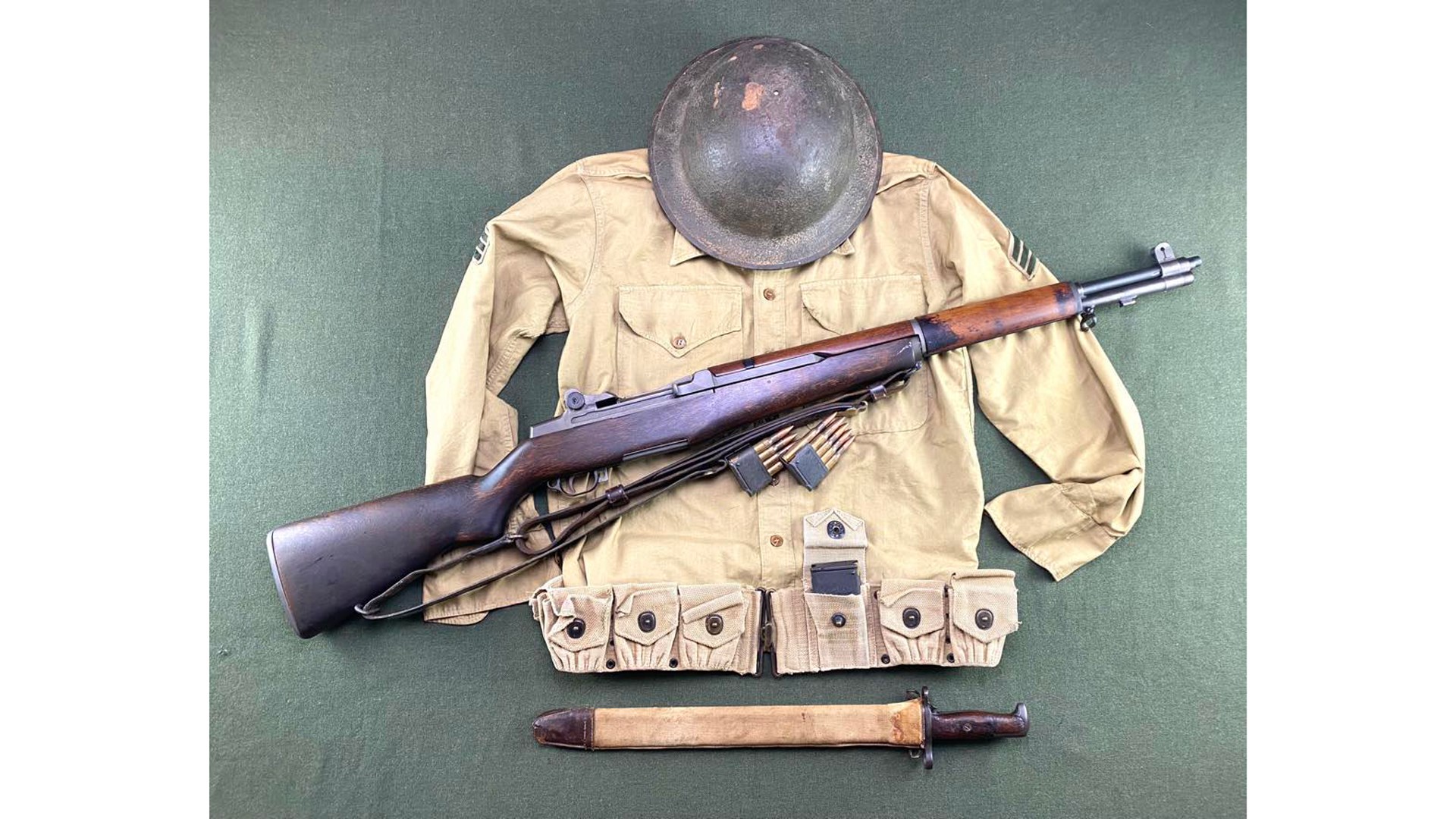 m1 garand shown with gear jacket helmet bandolier bayonet gun rifle angled across clothing magazine en bloc clip ammunition