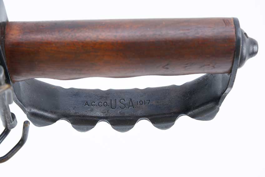 Close-up view of walnut hand and handguard&#x27;s stamping with &quot;A.C. CO. USA 1917&quot; shown on white background.