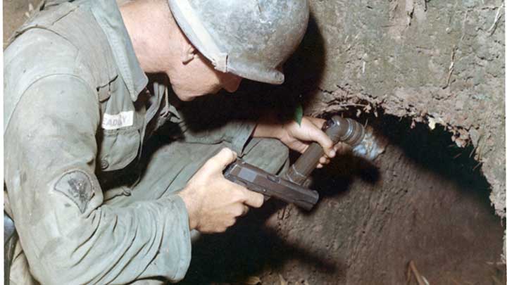 The entrance to Hell:  A GI of the 25th Infantry checks the entrance to a VC tunnel outside Phu Hoa Dong during Operation Cedar Falls in January, 1967.