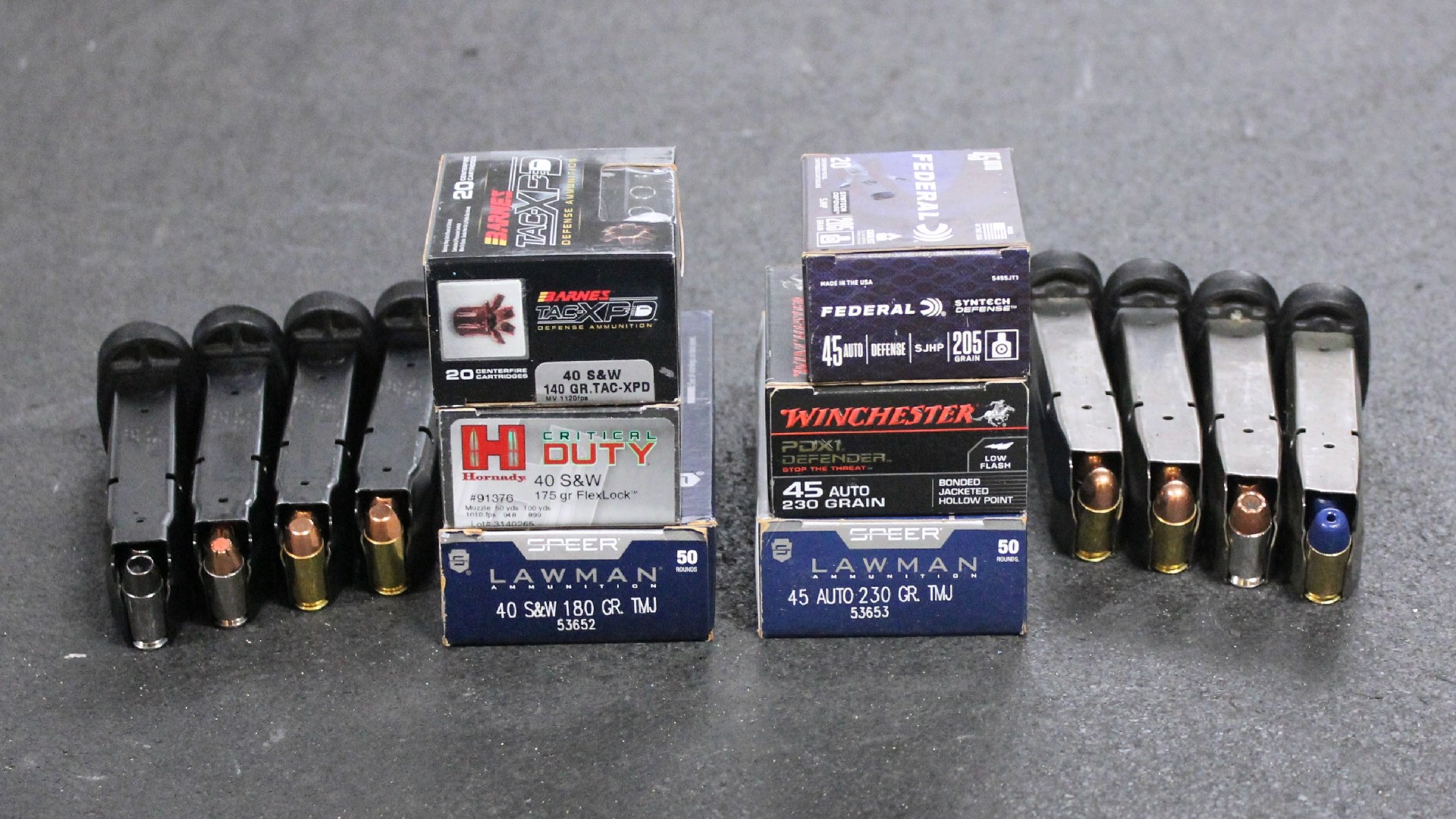 Pistol magazines shown with ammunition boxes in 9 mm .40 S&W and .45 ACP