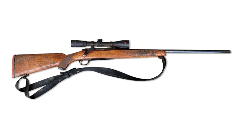 Ruger Model 77 in .220 Swift right-side view wood stock bolt-action rifle with sling on white background