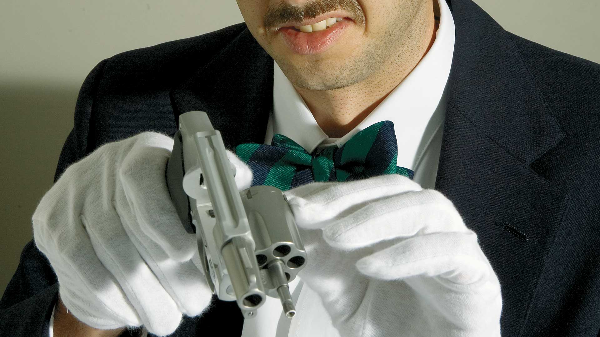 man white gloves gun revolver cleaning bowtie black coat