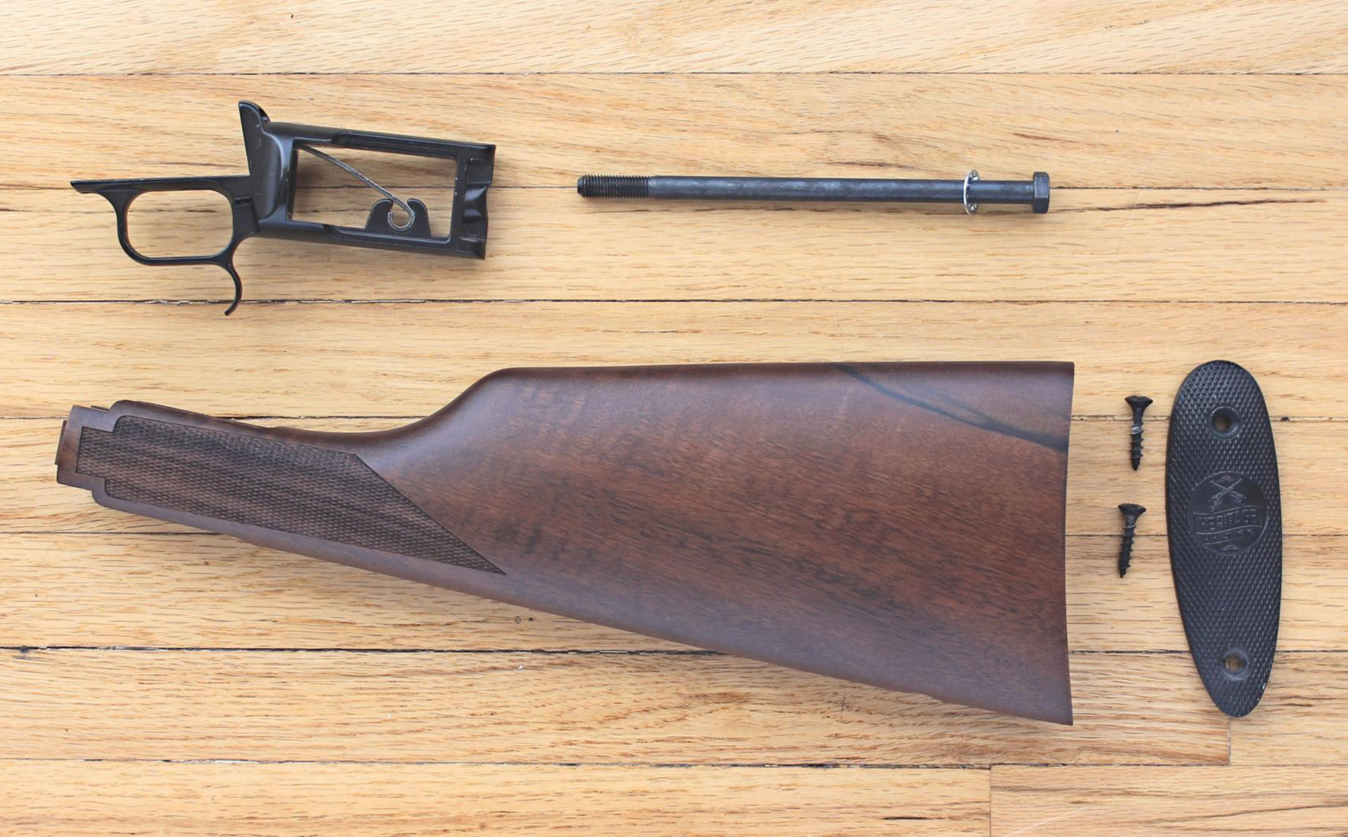 The Rancher backstrap assembly uses a long stock screw to support the walnut shoulder stock. The stock is capped off with a polymer buttplate supported by two-Philips head screws.
