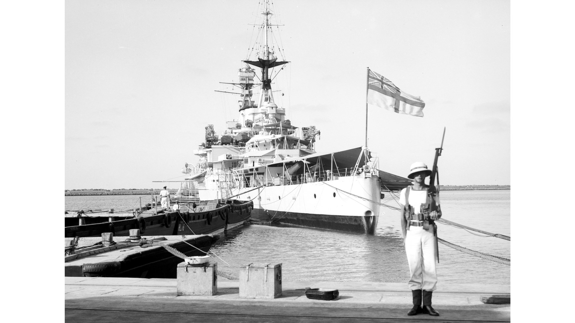 A show of force:  A Royal Marine stands guard ashore while the battle cruiser HMS Repulse (6x 15-inch guns) is moored at Haifa.  Library of Congress